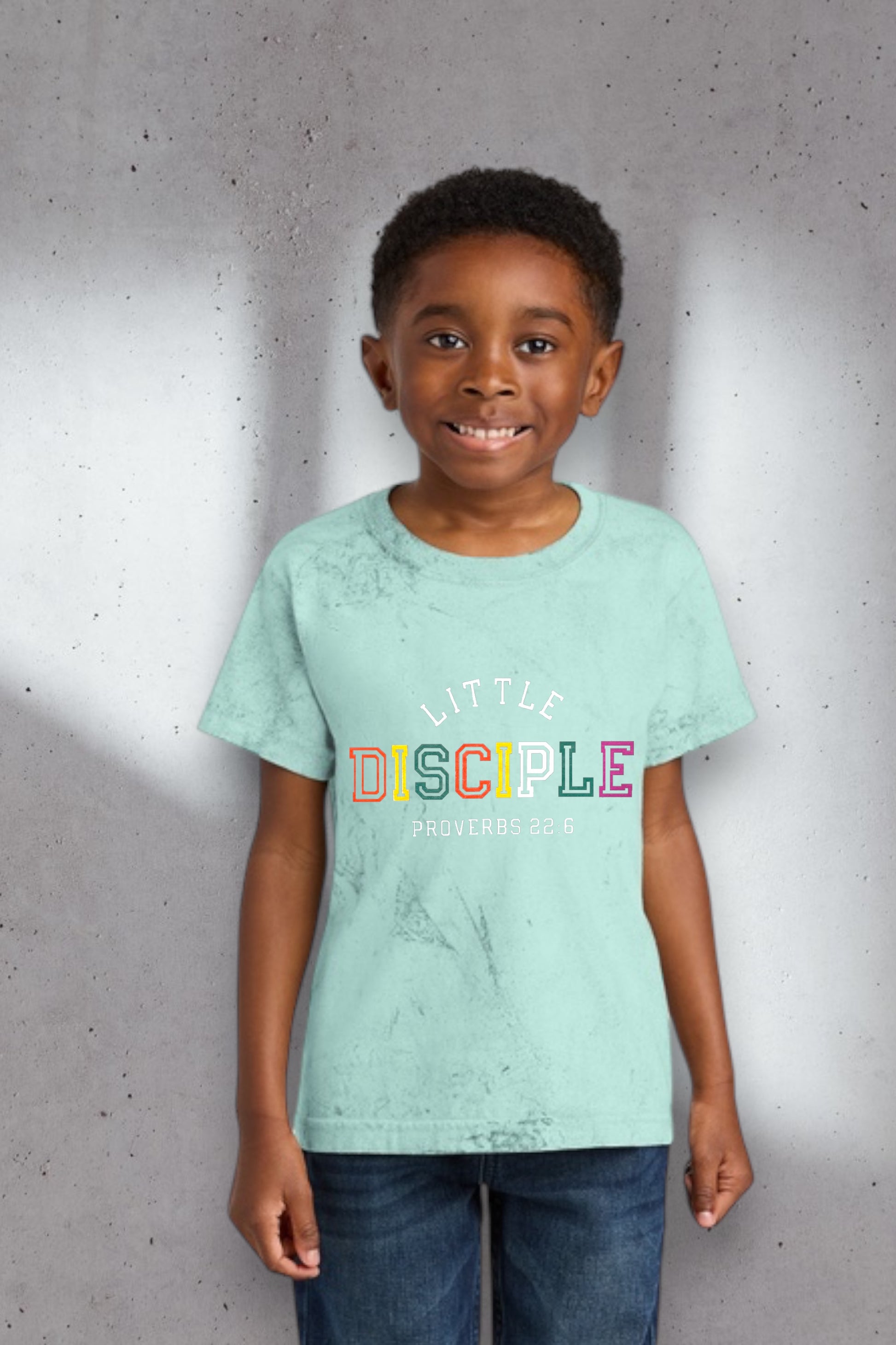 Child wearing a light blue t-shirt with colorful text against a gray background