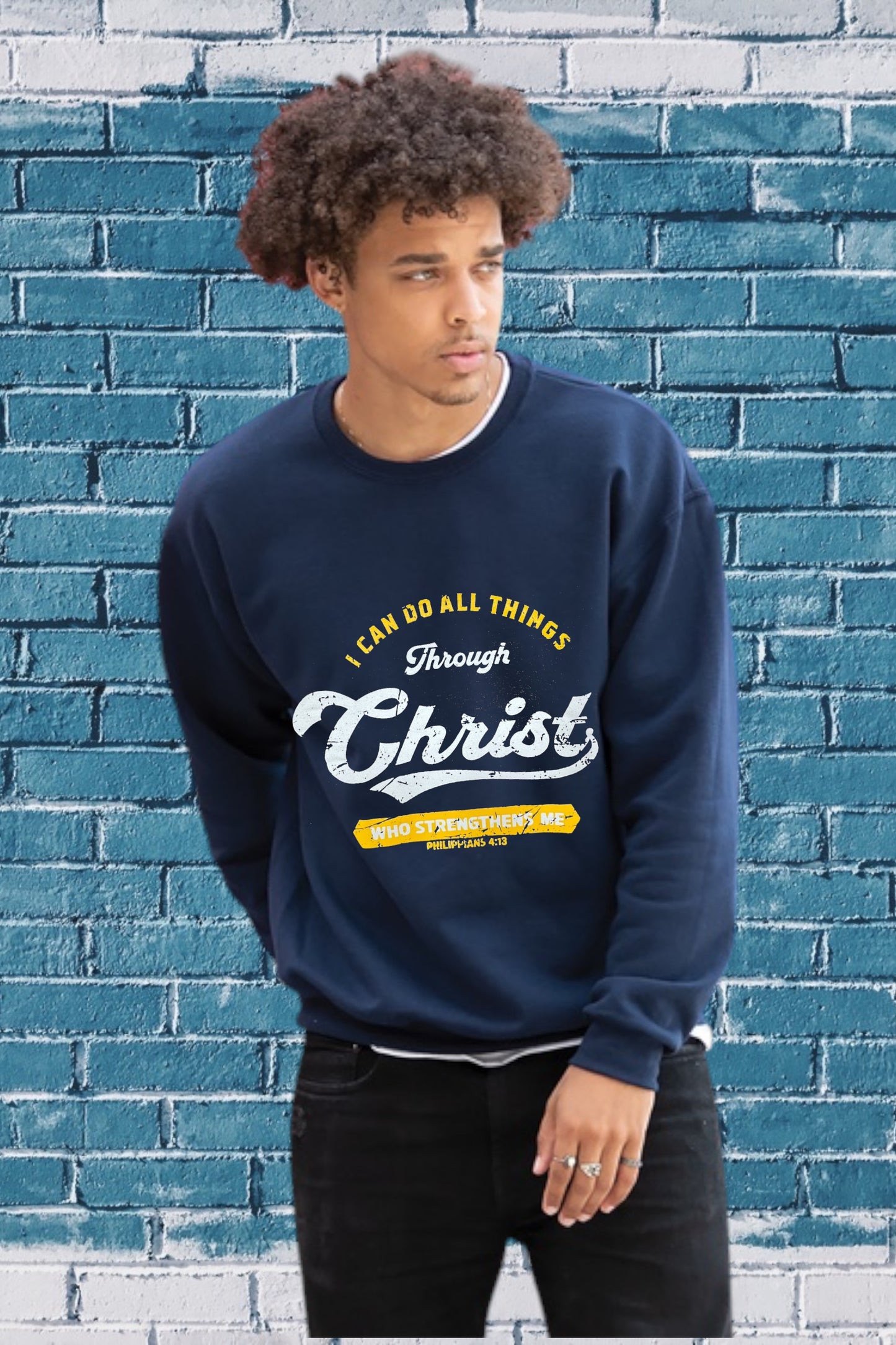 Navy blue sweatshirt with the Bible verse “I CAN DO ALL THINGS Through Christ WHO STRENGTHENS ME PHILIPPIANS 4:13” printed in yellow and white, featuring “Christ” in large cursive font.
