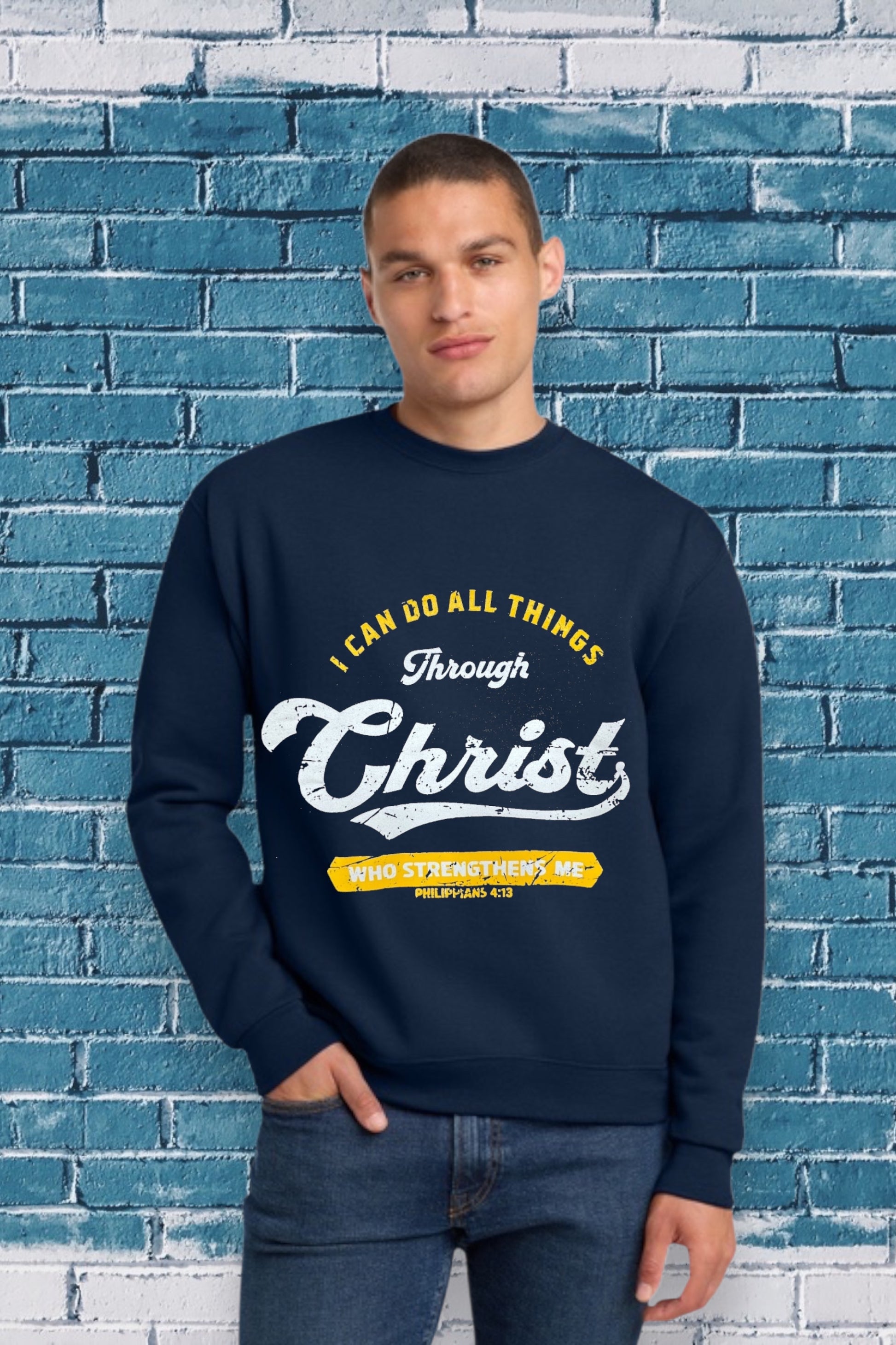 Navy blue sweatshirt with the Bible verse “I CAN DO ALL THINGS Through Christ WHO STRENGTHENS ME PHILIPPIANS 4:13” printed in yellow and white, featuring “Christ” in large cursive font.
